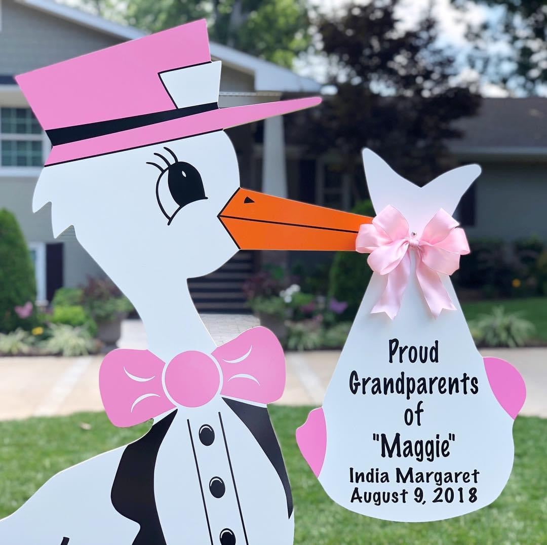 Pink lawn stork sign with personalized bundle announcing new granddaughter