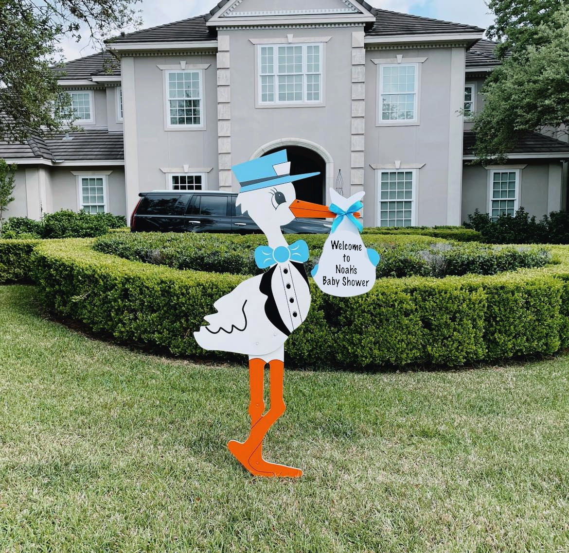 Blue stork welcoming guests to a baby shower hosted at a home